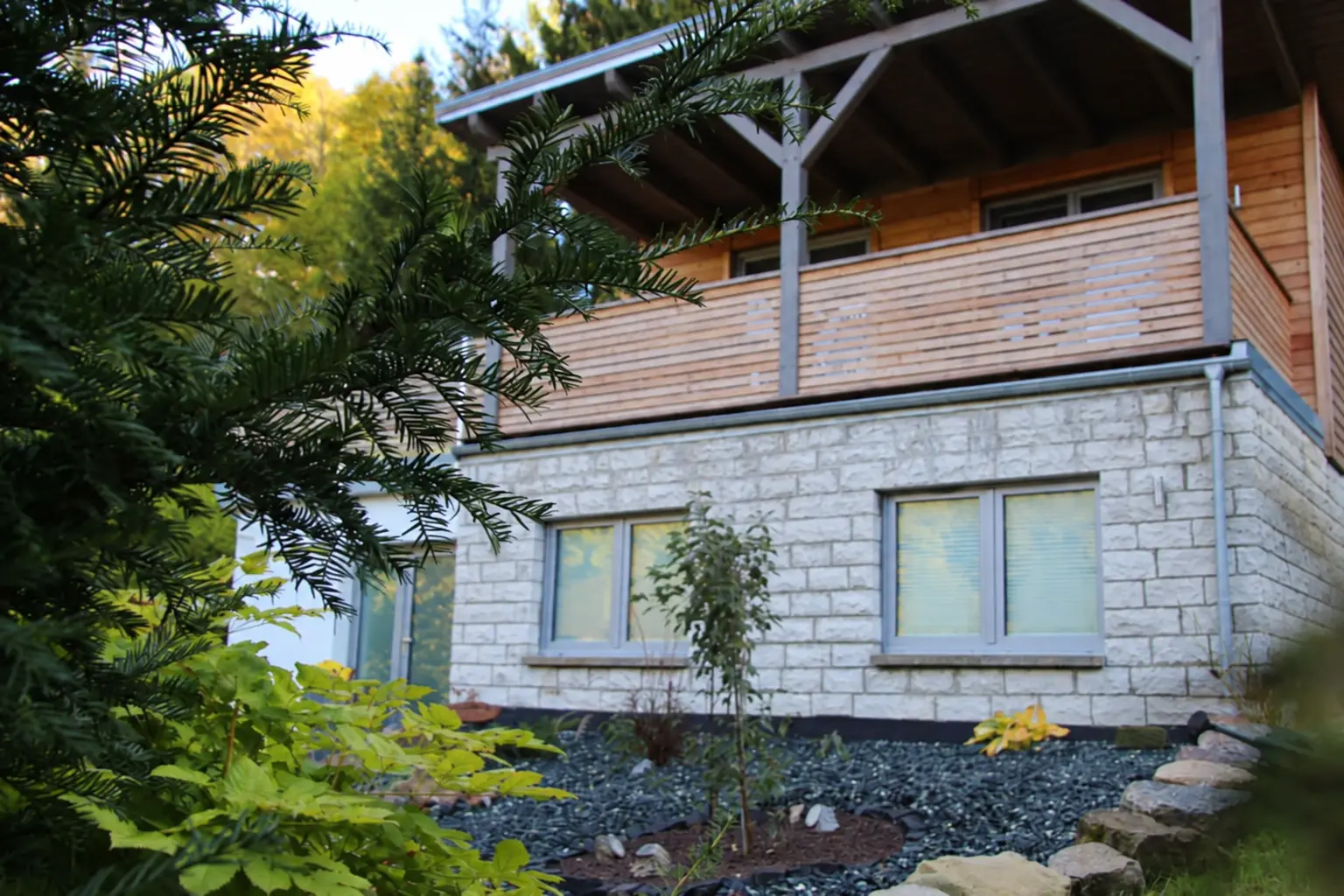 Das Kleine Waldhäuschen mit überdachter Holzterrasse, eingebettet in den grünen Garten